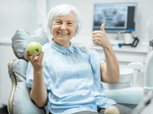 Mulher idosa segurando uma maçã verde